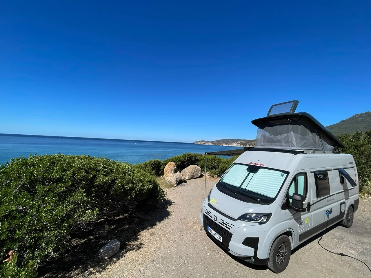 Dethleffs Globetrail an einer Küstenstraße mit Blick über die Bucht