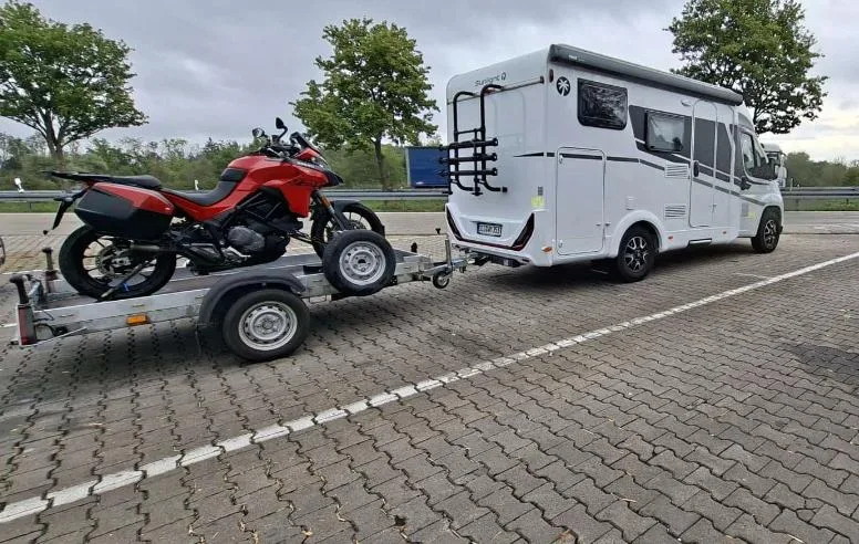 Sunlight Adventure V60 mit Motorradanhänger auf einem Rastplatz
